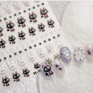 Detail of 3D embossed nail stickers featuring cartoon black cat and white rabbit designs
