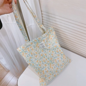 Floral canvas tote bag with yellow-green flower patterns and shoulder strap detail