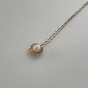 Minimalist gold shell pendant necklace with a white round pearl for a modern look