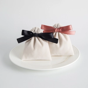 Detail of off-white velvet jewelry pouches with elegant satin ribbon drawstrings