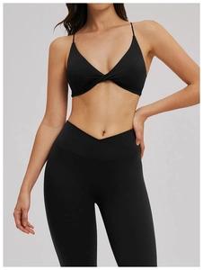Détail de la brassière croisée et du legging en tissu noir mat extensible