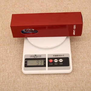 Detail view of the Christmas LED lamp being weighed on a digital scale at 93 grams