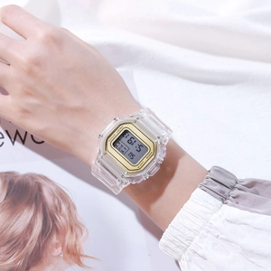 Wrist view of a transparent digital watch with gold bezel on a stylish magazine background