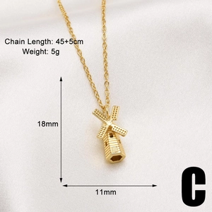 Detailed view of gold-plated windmill pendant with engraved blades on soft satin