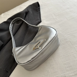 Metallic silver crescent underarm bag in premium PU leather on white textured fabric