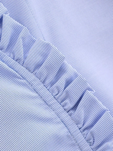Macro shot of blue and white striped poplin fabric with pleated ruffle detail and stitching