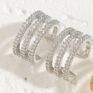 Macro detail of silver layered ear cuff with brilliant zircon pavé on stone surface
