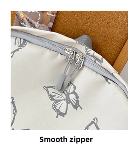 Macro view of smooth double-headed grey zippers on butterfly pattern backpack