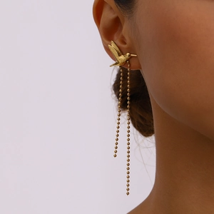 Close-up of golden hummingbird stud earring with long bead chain tassels on ear