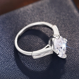 Macro shot of marquise-cut crystal ring with step-cut side stones on dark leather