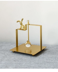 Detail of Nordic golden rabbit metal napkin holder with a crystal ball and polished base