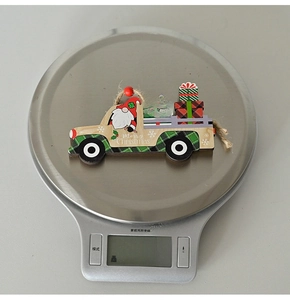 Christmas wooden truck ornament showing weight 11.1g on a digital scale for decor