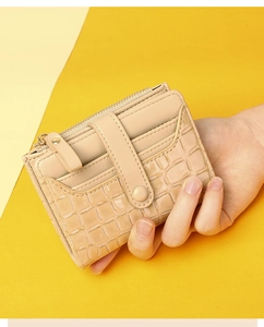 Detail showing beige croc-textured card holder with gold snap closure and zipper compartment