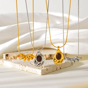 Detail of gold and silver textured pendant necklaces on elegant silk and stone