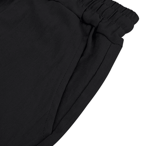 Detail of black polo shorts featuring elastic waistband, side pockets and high-density knit