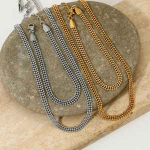 Minimalist gold and silver triple-row bead chain necklace set on natural stone