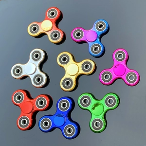 Top view of eight colorful electroplated tri-spinner fidget toys with metallic finish