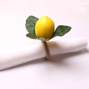 Detail of napkin ring with faux yellow lemon and green leaves on a twine rope loop