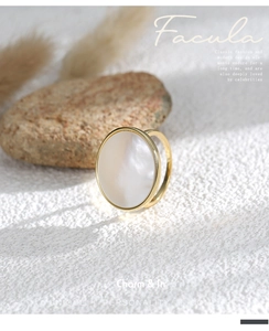 Macro detail of gold vintage ring featuring a large round iridescent mother of pearl stone