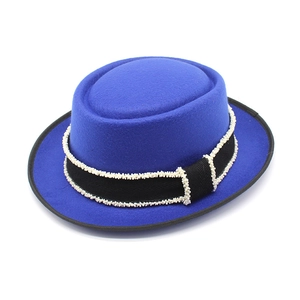 Klein blue wool pork pie hat with black ribbon and pearl details on white background