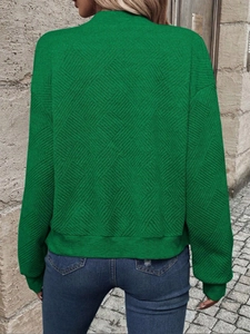 Detailed back view of green knit jacket featuring textured diamond quilt pattern and zip