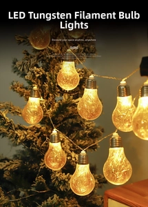 Macro shot of warm LED tungsten bulb decorations hanging on a festive Christmas tree branch