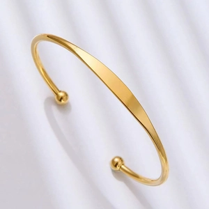 Minimalist gold-plated C-shaped cuff bracelet with polished finish and ball ends