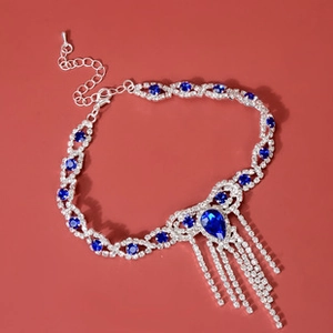 Detail of silver necklace with blue teardrop crystal and sparkling rhinestone tassels