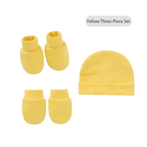 Flat lay of lemon yellow newborn knit hat with matching gloves and socks set