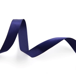 Close-up of elegant dark blue satin ribbon with smooth glossy texture on white background