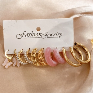 Detail view of 5-piece earring set with pink resin, faux pearls, and gold finish