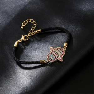 Detail of Hamsa Hand charm with colorful cubic zirconia on black woven rope bracelet