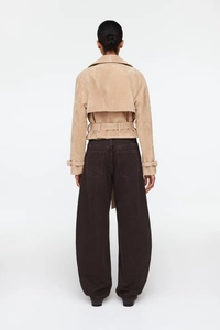 Back view of beige suede short jacket with belt and wide-leg jeans on model