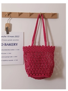 Close-up of rose red hollow mesh cotton cord weave on the stylish beach shoulder bag