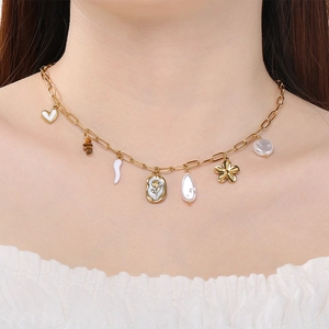 Vue détaillée d'un collier doré en acier inoxydable avec des breloques fleurs et perles.