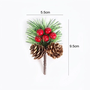 Artificial pine branch with red berries and natural pine cones for Christmas decor