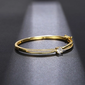 Elegant gold open bangle featuring a round zircon center stone and micro-pave accents