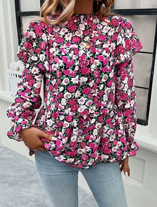 Detail of floral long sleeve blouse with elegant ruffle trim and pink blossom patterns