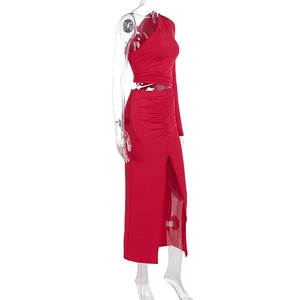 Detail of red ruched knit fabric featuring a side slit and elegant asymmetric neckline