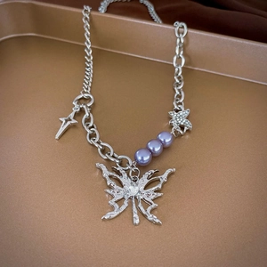 Detail of silver lava butterfly necklace with purple pearls and rhinestone cross charm