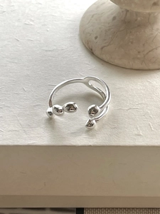 Detailed top view of a 925 silver irregular open ring with sphere accents on a stone base