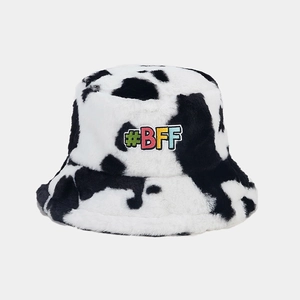 Close-up of fluffy cow print bucket hat with colorful #BFF embroidered patch and soft texture