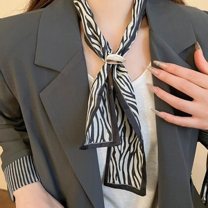 Detail of zebra pattern silk scarf necklace with a sleek silver metallic buckle accent
