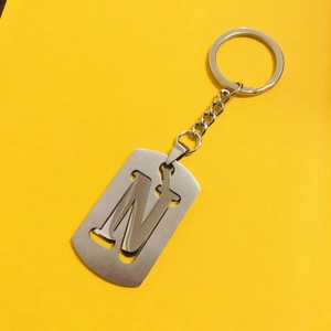 Minimalist stainless steel keychain with hollow letter N on bright yellow background