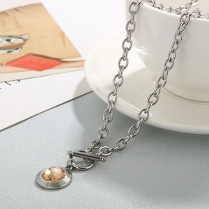 Detailed view of silver OT toggle chain necklace with amber crystal circular pendant