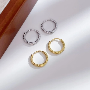 Classic gold and silver twisted hoop earrings with a minimalist woven stainless steel texture