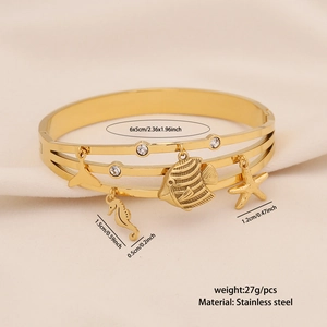 Close-up of gold stainless steel multi-layer bracelet with sea life charms and crystals