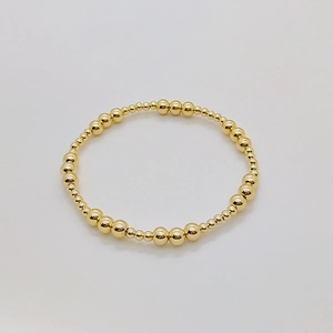 Dettaglio del bracciale elastico con perline placcate in oro 18K di varie dimensioni