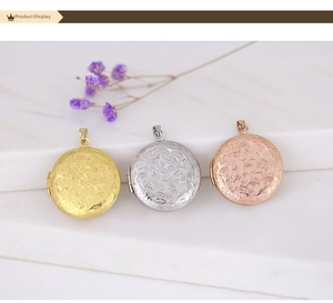 Three engraved heart locket necklaces in gold, silver, and rose gold on a marble background