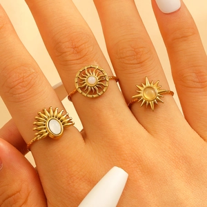 Close-up of three gold sun-themed rings with radiant patterns and inlaid gemstones